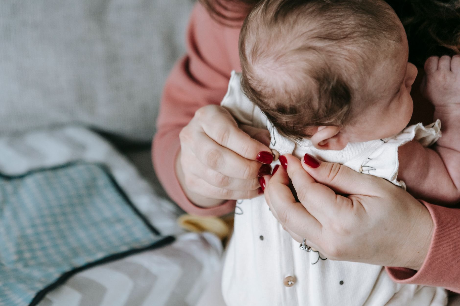 A mother gently caring for her newborn baby, highlighting tender caregiving moments
